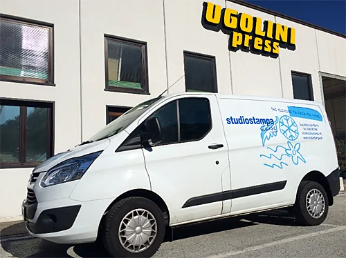 La sede Ugolini Press con l'insegna sulla facciata e un furgone decorato